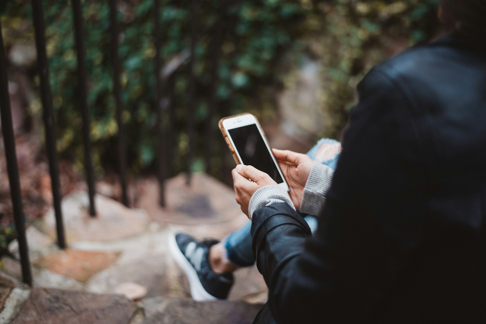 A teen holding a phone, screen partially visible