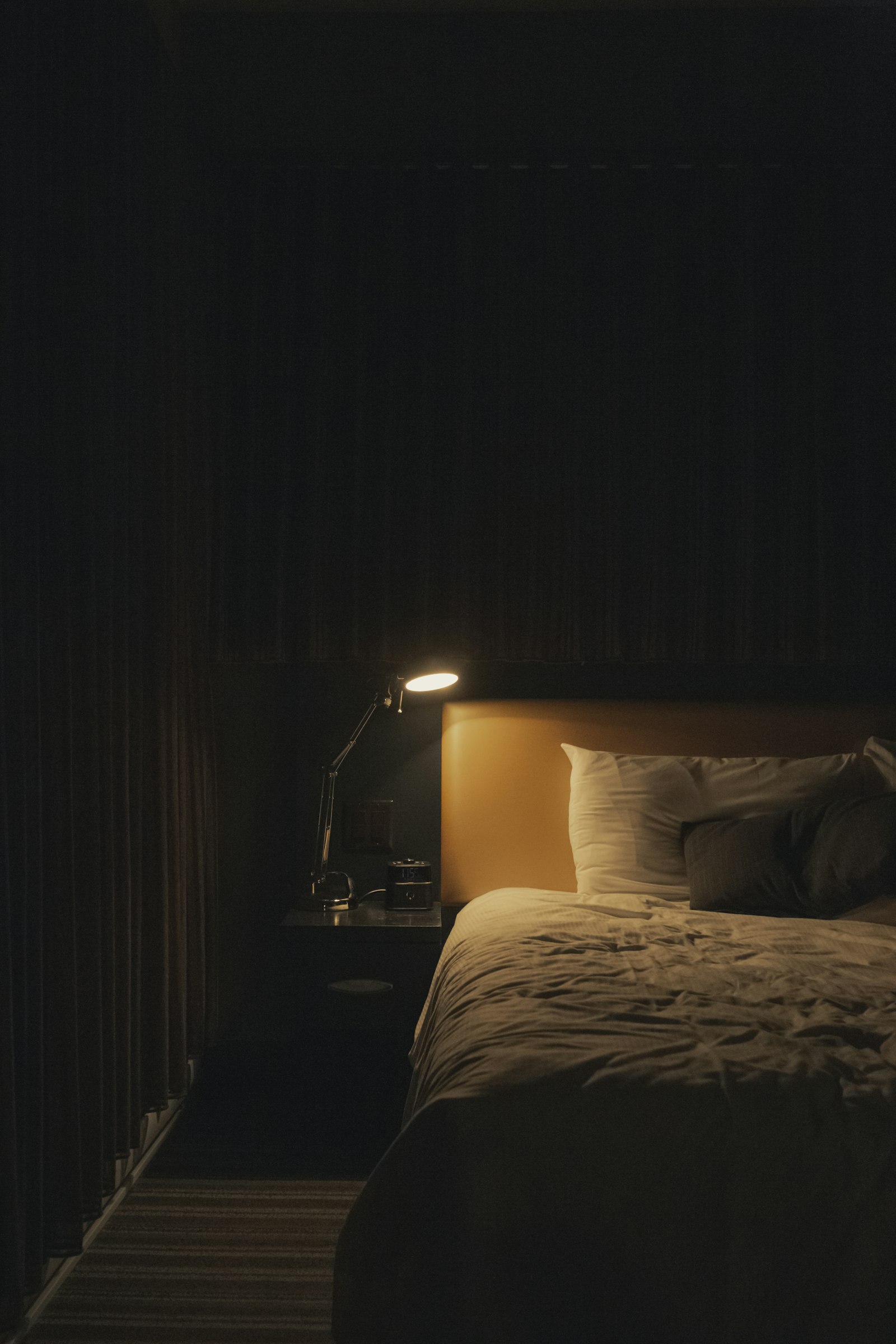 A teen at night holding a phone, face turned away